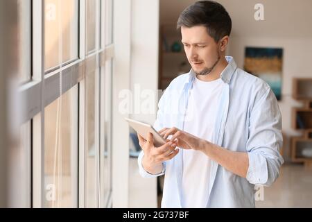 Handsome man using tablet computer at home Stock Photo