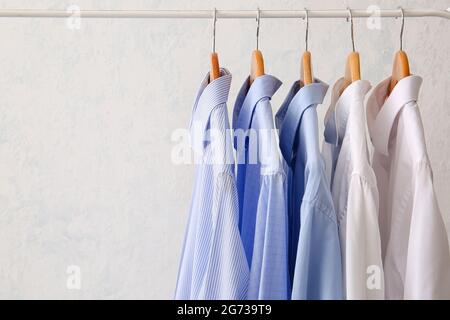 https://l450v.alamy.com/450v/2g739t9/rack-with-clothes-after-dry-cleaning-on-light-background-2g739t9.jpg
