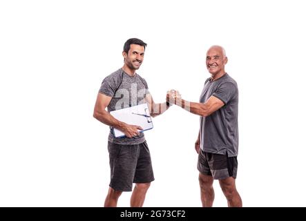 Fitness trainer with a workout pad shakes hands with a retired man in sports uniform. On a white isolated background. Stock Photo