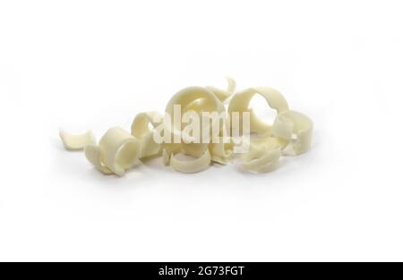 White Chocolate Curls Isolated On White Background. Group of chocolate shavings. Chocolate roll. Stock Photo