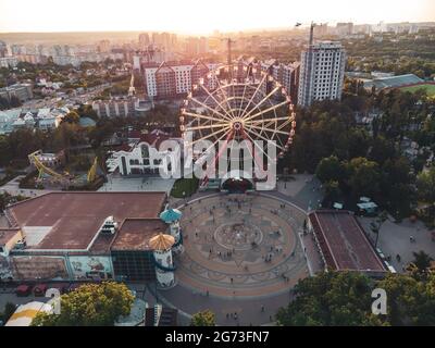 Ferris wheel spinning aerial sunset view in Kharkiv city center, amusement Park of Maxim Gorky. High attraction for recreation and city observation Stock Photo