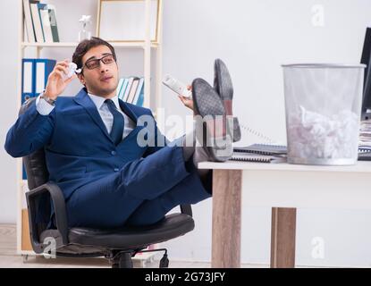 Young handsome businessman employee working in office in paperwork concept Stock Photo