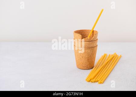 Waffle coffee cups and pasta straws on neutral background with copy space. Zero waste, plastic free, stop pollution, ecological concept Stock Photo