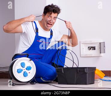 The funny man doing electrical repairs at home Stock Photo