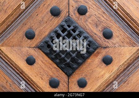Detail of Old door. Iron Mesh on the wooden door with metallic rivets on it. Antique Decor Stock Photo