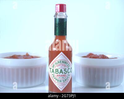 Red Tabasco Sauce bottle and two bowls of salsa Stock Photo