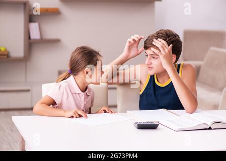 Teenager and his small sister staying at home during pandemic Stock Photo