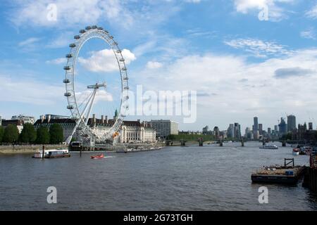 Boats cruise along the River Thames passing the famous sights such as the London Eye, County Hall and Westminster Bridge, London, UK. Stock Photo