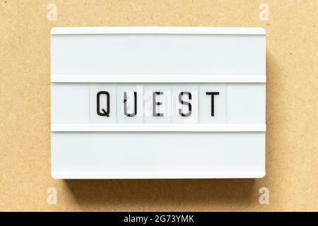 Lightbox with word quest on wood background Stock Photo