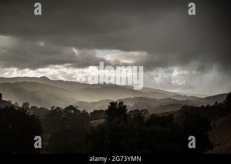 Santa Cruz Mountains, showing the peak of Mount Umunhum, during a hail storm. Low light, very little color - dark in the day time. Stock Photo