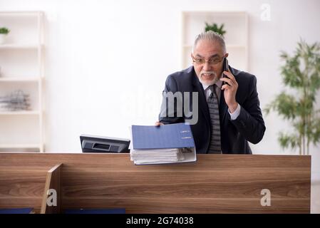 Aged businessman employee sitting at workplace Stock Photo