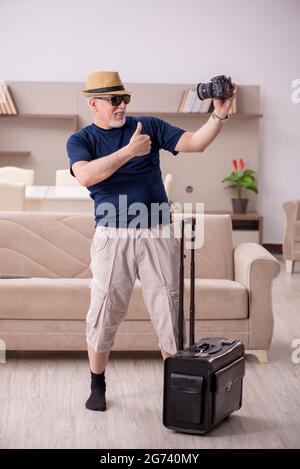 Old male tourist preparing for trip at home Stock Photo
