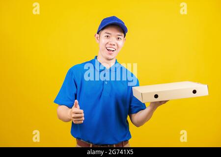 Portrait excited delivery service man standing he smile wearing blue t-shirt uniform hold give food order pizza cardboard boxes and show thumb up fing Stock Photo