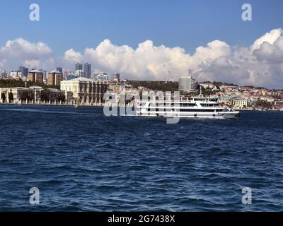 A ferry boat passes the Ciragan Palace on the Bosphorus Sea in  Istanbul, Turkey Stock Photo