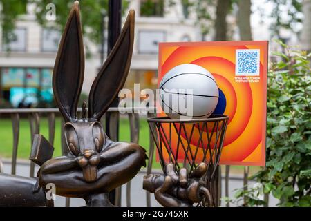 London, UK. 10th July, 2021. The Bugs Bunny statue in Leicester Square, part of the long-term Scenes in the Square sculpture trail now includes a life-sized basketball and hoop, along with a floral display in the colours of the Tune Squad to celebrate the release of Space Jam: A New Legacy in cinemas from the 16th July. Credit: SOPA Images Limited/Alamy Live News Stock Photo
