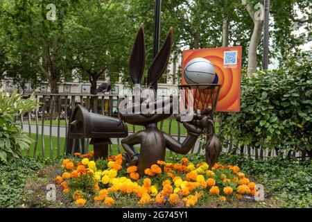 London, UK. 10th July, 2021. The Bugs Bunny statue in Leicester Square, part of the long-term Scenes in the Square sculpture trail now includes a life-sized basketball and hoop, along with a floral display in the colours of the Tune Squad to celebrate the release of Space Jam: A New Legacy in cinemas from the 16th July. Credit: SOPA Images Limited/Alamy Live News Stock Photo