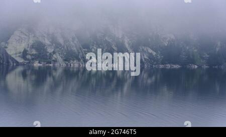Morning fog in the Cavallers reservoir (Boí Valley, Aigüestortes i Estany de Sant Maurici National Park, Catalonia, Spain, Pyrenees) Stock Photo