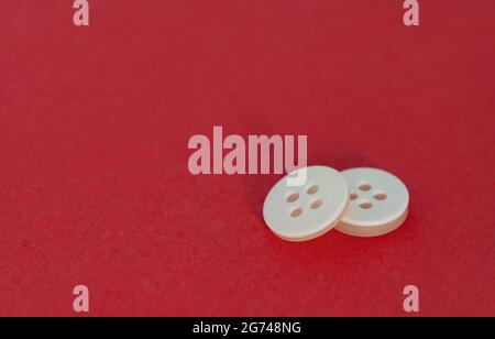 A pair of small white buttons. Selective focus points. Blurred background Stock Photo