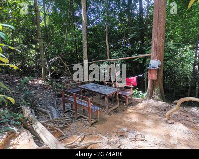 Wooden picnic table and benches surrounded by trees in rainforest mountain. A place to relax for people hiking in tropical forest or jungle. Gunung Pa