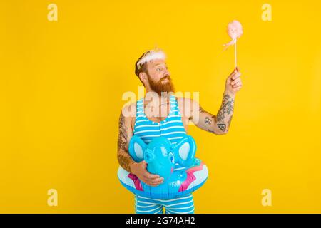 Happy man with life buoy ,princess crown and magic wand acts like a fairy Stock Photo