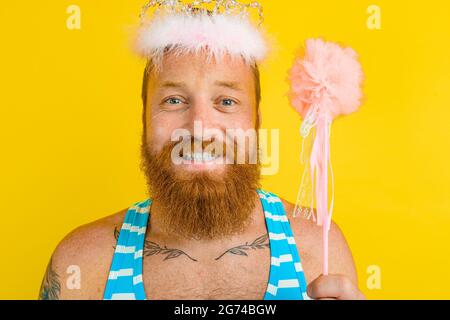 Happy man with princess crown and magic wand acts like a fairy Stock Photo