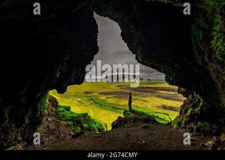 Person standing in front of Loftsallahellir Cave. Stock Photo