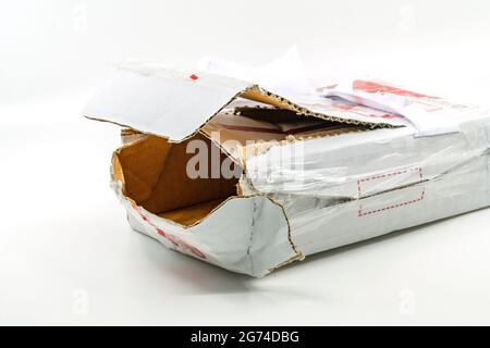 Torn white parcel box on white background. Close up large hole on the parcel box. The stolen internal package box. Stock Photo