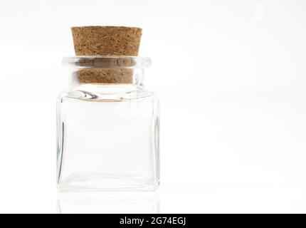 Small square glass shape container and cork with the bright light on white background. Stock Photo