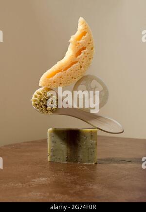 Balancing skincare items - handmade soap, natural bristles brush, washcloths on a beige background, minimalism with copying space Stock Photo