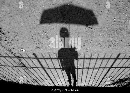 A grayscale shot of a boy with an umbrella Stock Photo