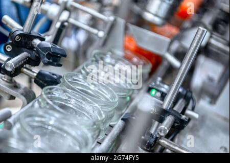 Machine for filling red caviar into glass jars. Filling equipment, food industry Stock Photo