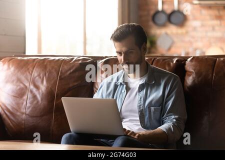 Focused adult student, remote employee using laptop Stock Photo