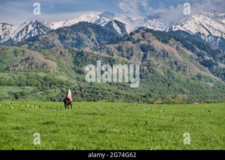 Kazakh girl in traditional dress on horseback, Kazakhstan steppes Stock Photo