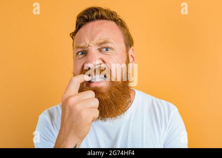 Doubter man with beard, tattoo and white t-shirt Stock Photo