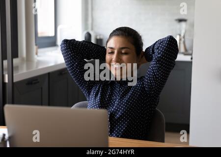 Happy relaxed employee working at computer from home Stock Photo