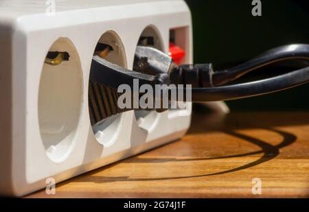 White portable electrical socket on wooden table, selected focus Stock Photo