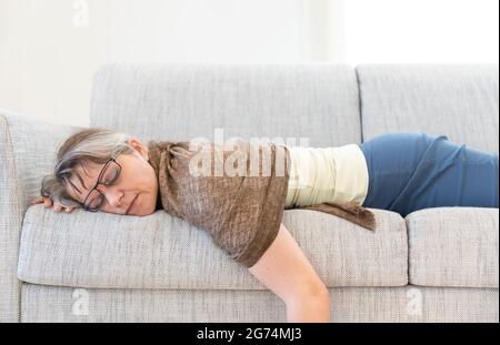 middle aged woman sleeping on a sofa Stock Photo