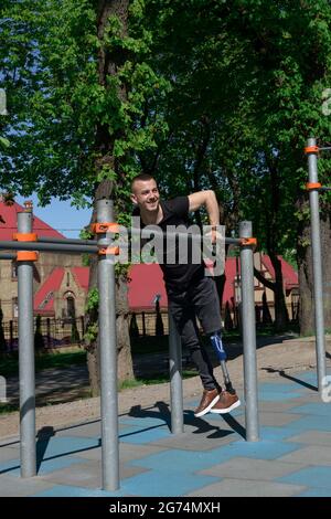 athletic young man with artificial leg working out on a bars Stock Photo