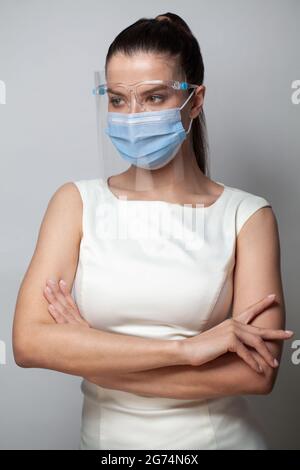 Female medical doctor wearing face shield and medical mask on white background. Portrait of female medical doctor wearing face shield for protect coro Stock Photo