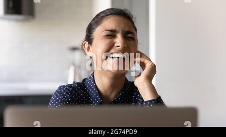 Happy excited Indian student girl laughing at laptop Stock Photo