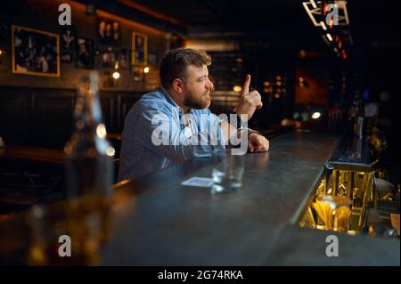 Bearded man sitting at the counter in bar Stock Photo