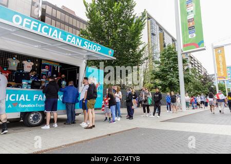 Wembley Park, UK. 11th July, 2021. Hundreds of England fans are flocking to Wembley this morning to soak up the atmosphere ahead of tonight's historic match with long queues forming at an official fan shop as fans rush to buy England merchandise. Wembley Stadium will host the Euro 2020 Final between Italy and England this evening. It is the first major final that England will have played in since winning the World Cup in 1966. Credit: amanda rose/Alamy Live News Stock Photo