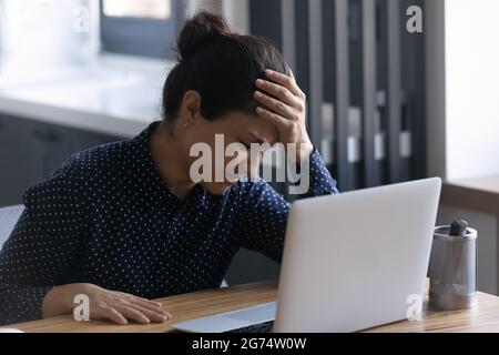 Unhappy Indian female employee upset about her mistake or problem Stock Photo