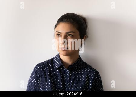 Thoughtful millennial Indian business woman, leader, owner, entrepreneur looking away Stock Photo