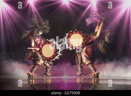 Taiko drummers on the stage. Expressive dynamic poses, stage lighting, smoke. Stock Photo
