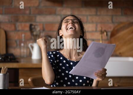 Excited overjoyed young woman getting investment income Stock Photo