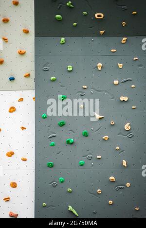 Abstract colorful of rock climbing wall with toe and hand hold studs., various colored grips at outdoor gym adventure park. Stock Photo