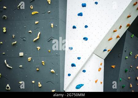 Abstract colourful of rock climbing wall with toe and hand hold studs., various grips at outdoor gym adventure park. Stock Photo