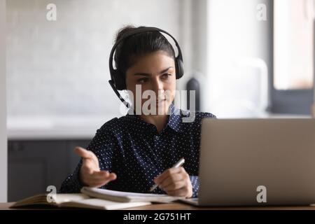 Indian female student in headphones watching and listening webinar Stock Photo