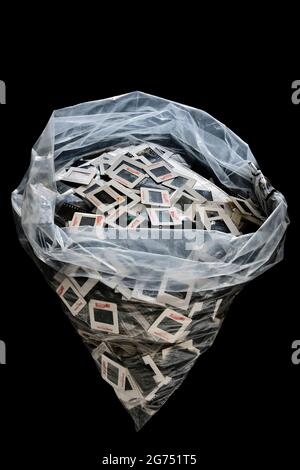A plastic bag of rejected/unwanted old slide transparenies on black background. Stock Photo